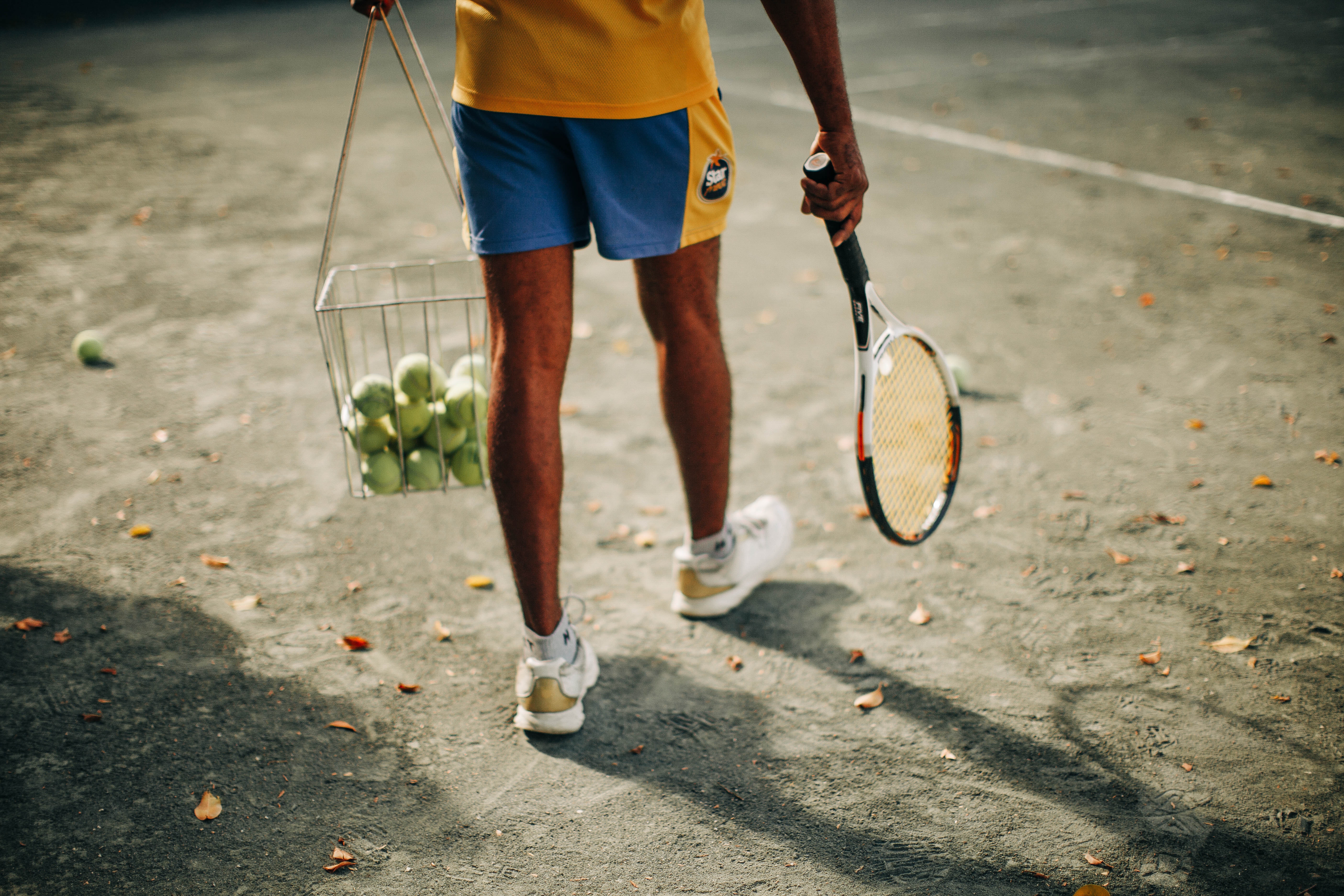 Człowiek z paletą do tenisa i pilkami